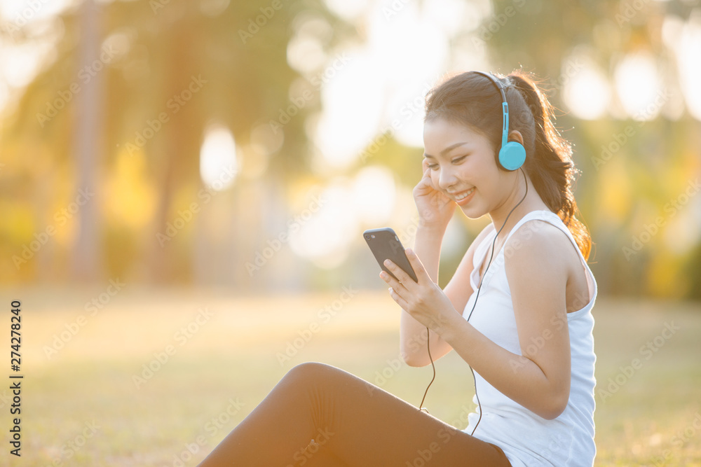 Fototapeta premium Beautiful Young Woman with Headphones Outdoors. Enjoying Music