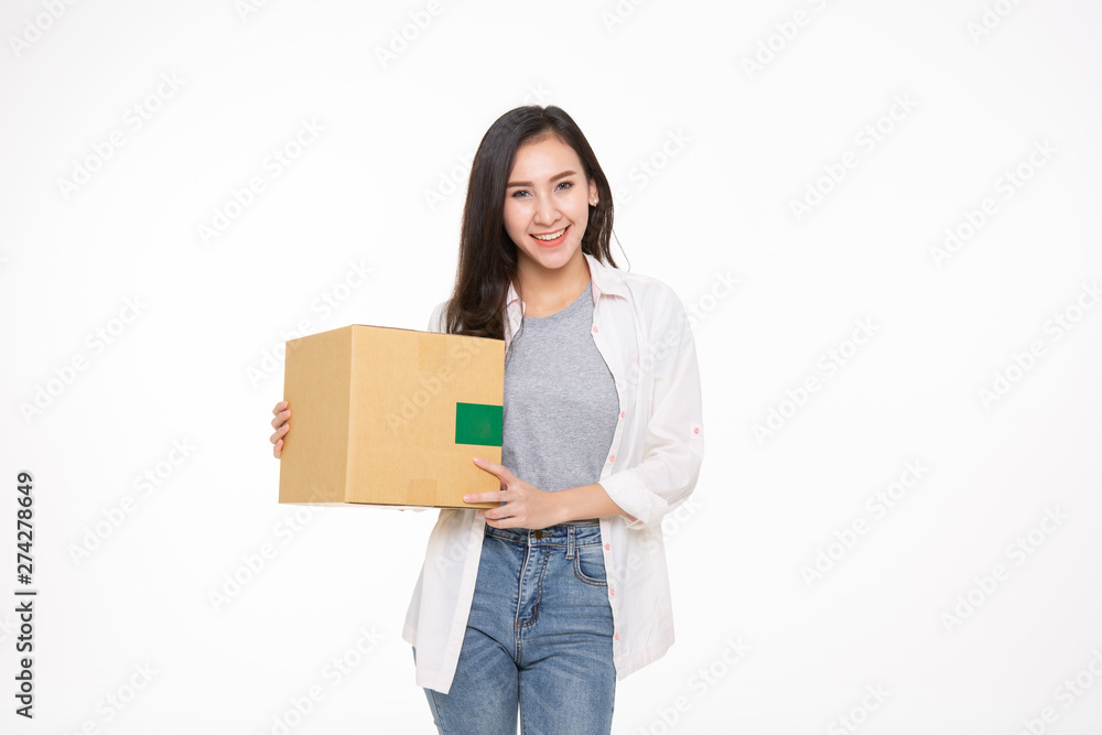 Delivery, relocation and unpacking. Smiling young woman holding cardboard box isolated on white background Delivery, relocation and unpacking. Smiling young woman holding cardboard box isolated on white background