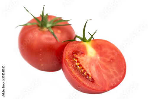 fresh tomato and half a tomato with dew drops isolated on white background