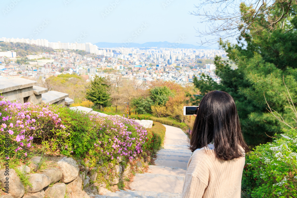 Asian woman taking pictures of Aerial view of Seoul city with smartphone