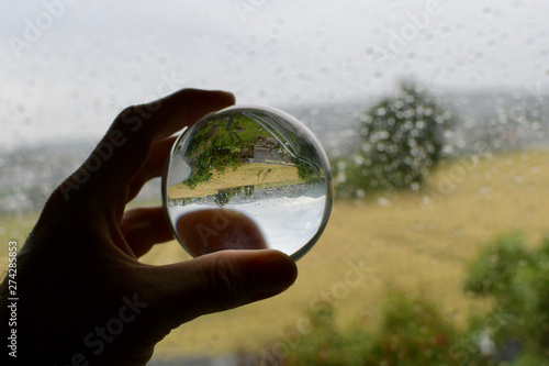 bad weather rainy day depressive mood raindrops on window pane with blurred background agricultre wheat field