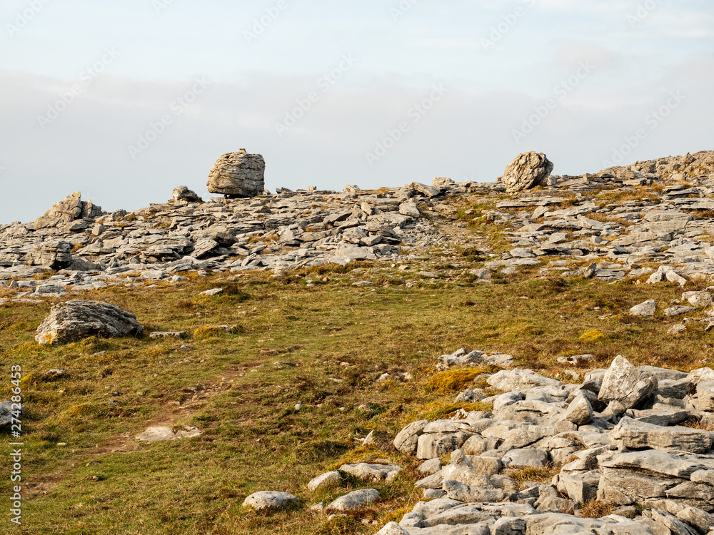 Terrain in Burren national park, County Clare, Ireland, Stones and small patch of grass. cloudy sky. Terrain in Burren national park, County Clare, Ireland, Stones and small patch of grass. cloudy sky.