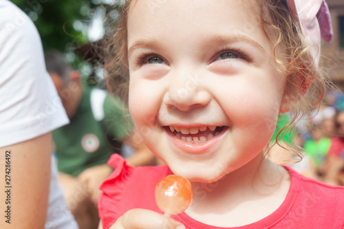 Little girl holding in hand a lollipop