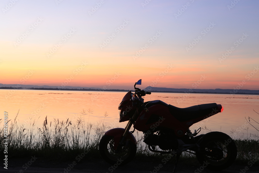 Motorcycle in silhouette at sunset at lake. Motorcycle in silhouette at sunset at lake.