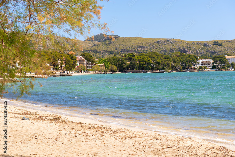 Obraz premium Sandy beach in Port de Pollenca (Puerto Pollensa), a popular family resort in the north-west of Mallorca. Spain