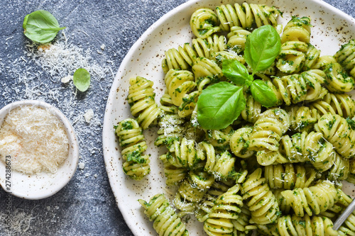 Pasta with pesto and parmesan on a concrete background. View from above.