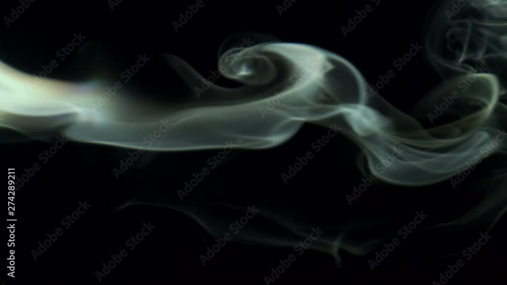 Vertical video screensaver - Thin trickle silvery smoke slowly rising graceful twists upward. Cigar smoke blowing from the left side. Closeup, isolated on black background. Vertical video screensaver - Thin trickle silvery smoke slowly rising graceful twists upward. Cigar smoke blowing from the left side. Closeup, isolated on black background.