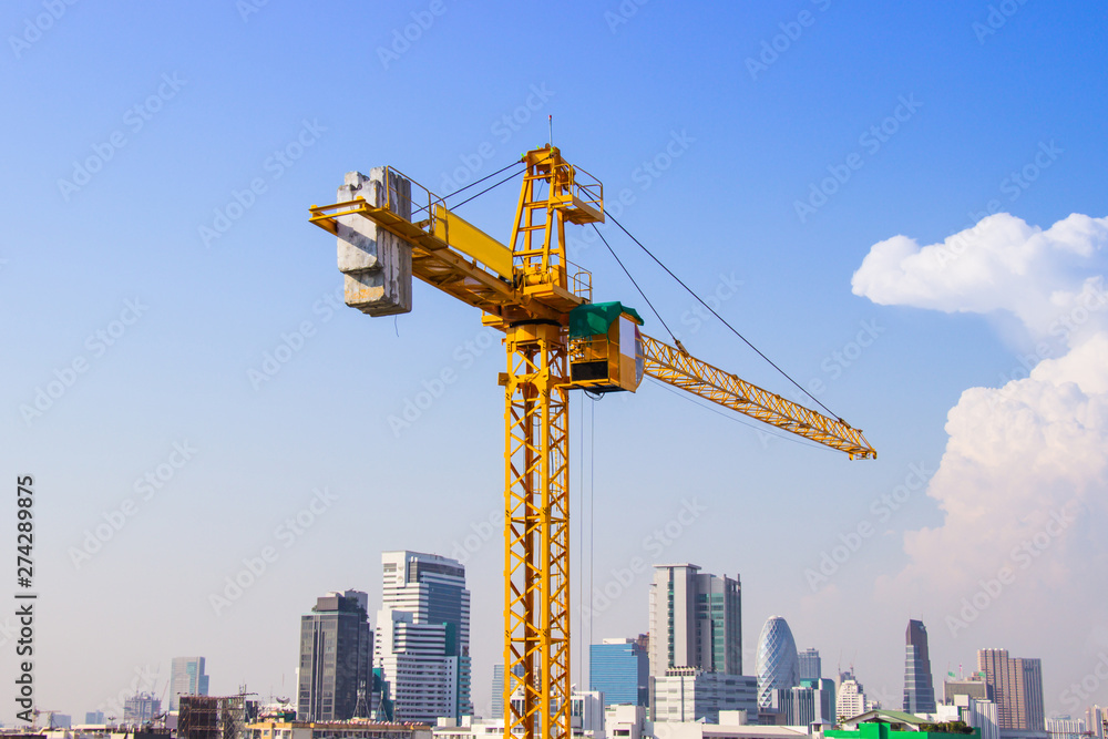 Crane is used in the construction of high buildings for tool of large industry under the blue sky and white clouds.