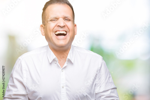 Middle age arab elegant man over isolated background Smiling and laughing hard out loud because funny crazy joke. Happy expression.