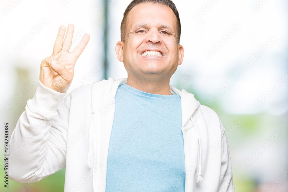 Middle age arab man wearing sweatshirt over isolated background showing and pointing up with fingers number three while smiling confident and happy. Middle age arab man wearing sweatshirt over isolated background showing and pointing up with fingers number three while smiling confident and happy.