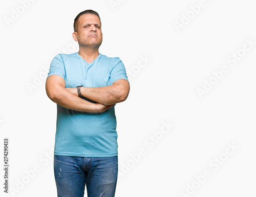 Middle age arab man wearing blue t-shirt over isolated background skeptic and nervous, disapproving expression on face with crossed arms. Negative person.