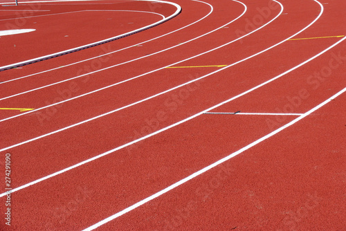 Red running track with white lines at the stadium