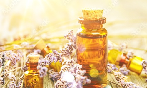 Pile of lavender flowers and a dropper bottle with lavender essence
