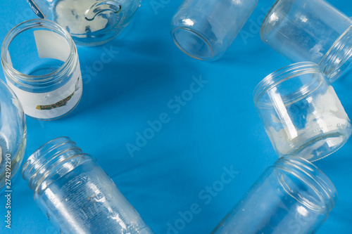 Isolated glass jars without lids flat on blue background with room for copyspace