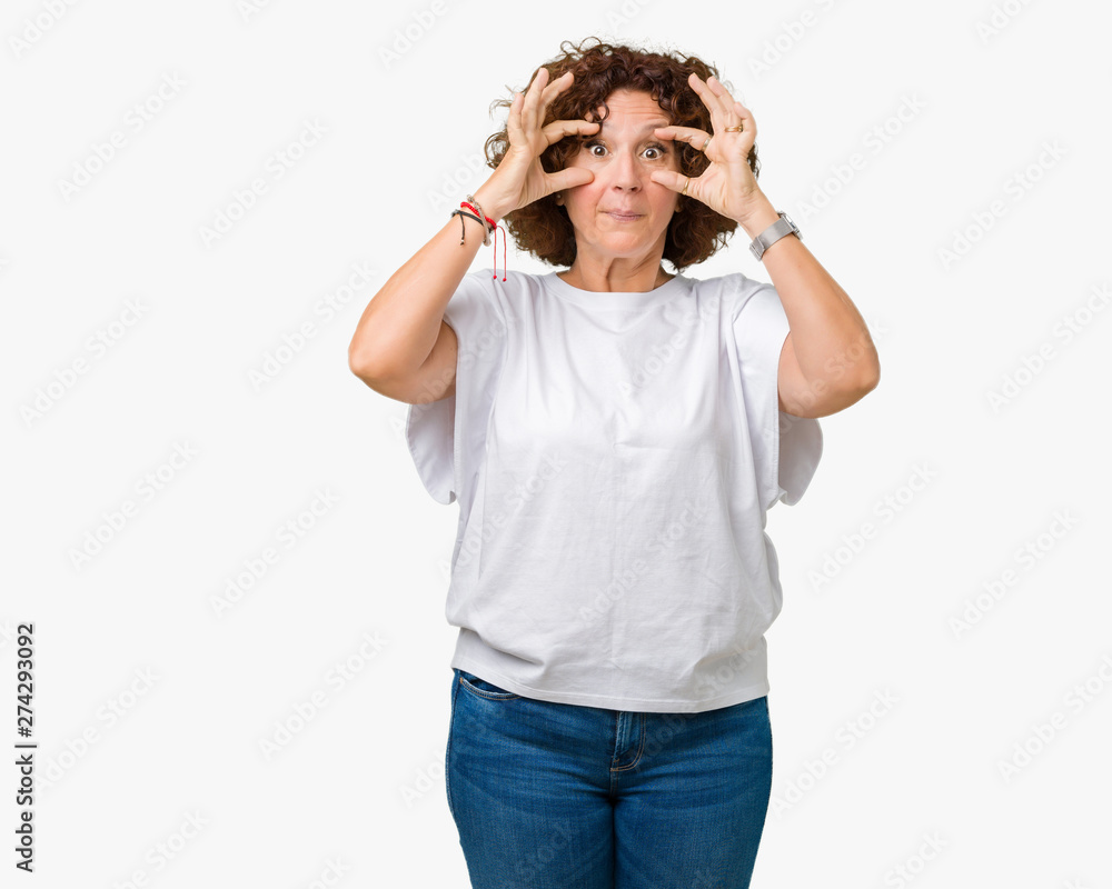 Beautiful middle ager senior woman wearing white t-shirt over isolated background Trying to open eyes with fingers, sleepy and tired for morning fatigue Beautiful middle ager senior woman wearing white t-shirt over isolated background Trying to open eyes with fingers, sleepy and tired for morning fatigue