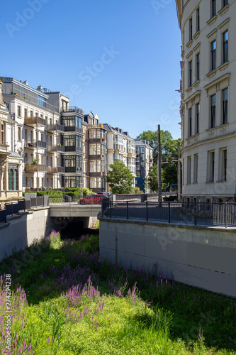 The river Elstermühlgraben in Leipzig with beautiful restored historic residential buildings at blue sky