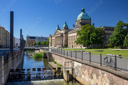 Panorama of the Federal Administrative Court Leipzig - Germany with River in the foreground at blue sky.At the courthouse is the text Federal Administrative Court in German