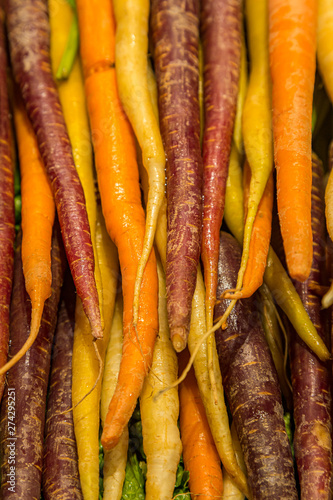Colourful rainbow carrots for sale on a market stall