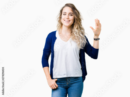 Beautiful young blonde woman over isolated background showing and pointing up with fingers number five while smiling confident and happy.