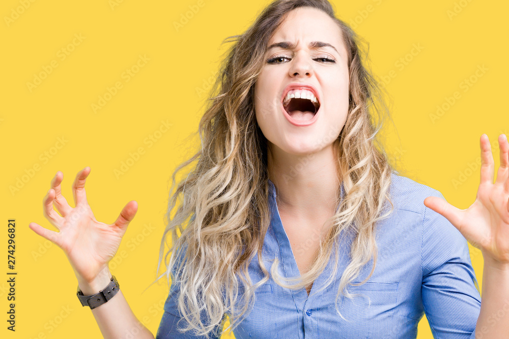 Beautiful young blonde business woman over isolated background Shouting frustrated with rage, hands trying to strangle, yelling mad Beautiful young blonde business woman over isolated background Shouting frustrated with rage, hands trying to strangle, yelling mad