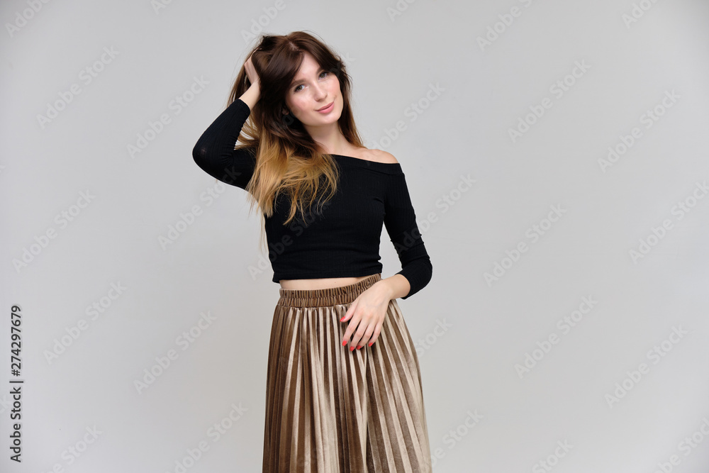Photo portrait of a beautiful pretty brunette girl in a black sweater on a gray background. A woman is satisfied with her life, she stands in front of the camera, smiling and talking. Made in studio. Photo portrait of a beautiful pretty brunette girl in a black sweater on a gray background. A woman is satisfied with her life, she stands in front of the camera, smiling and talking. Made in studio.