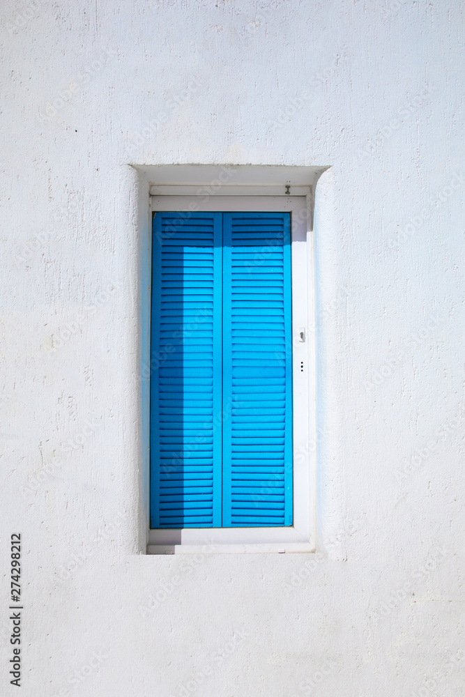Fototapeta premium Traditional Aegean style old white house and wall, colorful streets and greek blue window in Bodrum city of Turkey. White colored traditional architecture in Mykonos or Santorini Greece