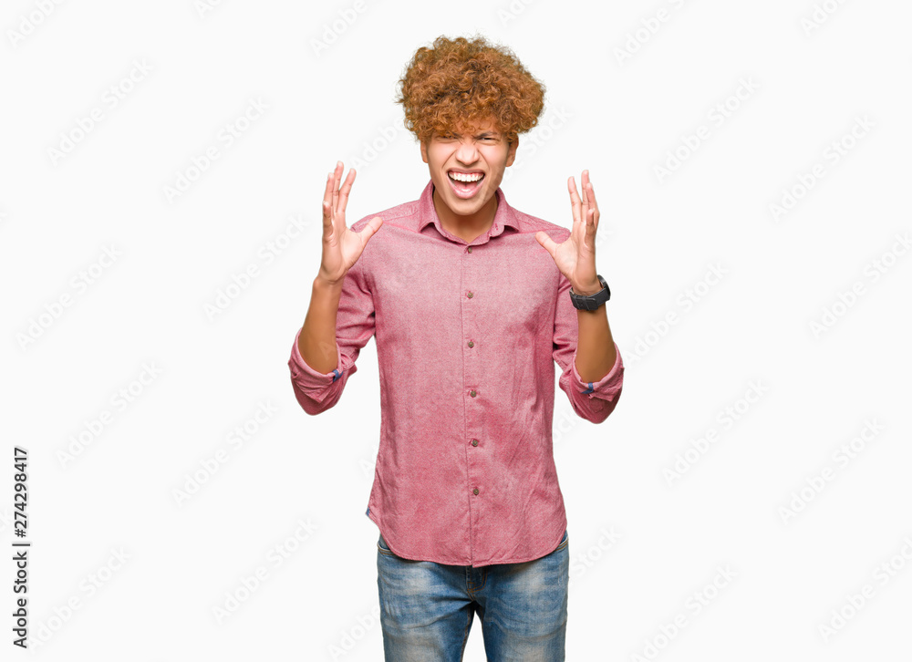 Young handsome business man with afro hair crazy and mad shouting and yelling with aggressive expression and arms raised. Frustration concept. Young handsome business man with afro hair crazy and mad shouting and yelling with aggressive expression and arms raised. Frustration concept.