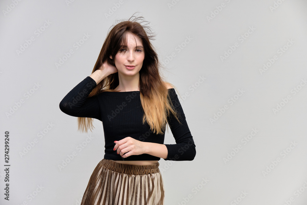 Photo portrait of a beautiful pretty brunette girl in a black sweater on a gray background. A woman is satisfied with her life, she stands in front of the camera, smiling and talking. Made in studio. Photo portrait of a beautiful pretty brunette girl in a black sweater on a gray background. A woman is satisfied with her life, she stands in front of the camera, smiling and talking. Made in studio.