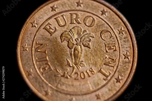 Reverse side of the coin one euro cent macro isolated on black background. Detail of metallic money close up. EU money