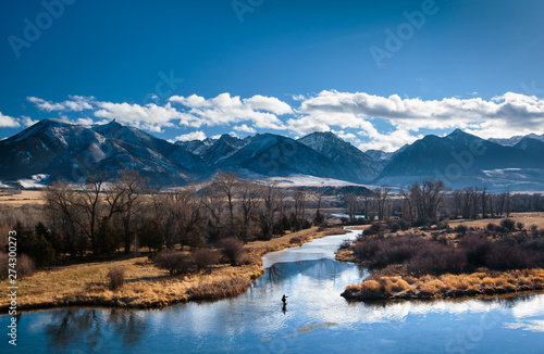 A man fly fishes in a spring creek in Paradise Valley, Montana on a beautiful wintry day.     photo