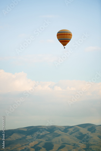 Hot air balloon flying over the hills photo