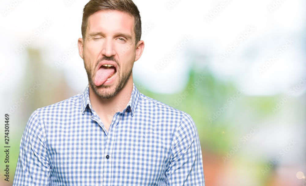 Handsome business man with blue eyes sticking tongue out happy with funny expression. Emotion concept. Handsome business man with blue eyes sticking tongue out happy with funny expression. Emotion concept.