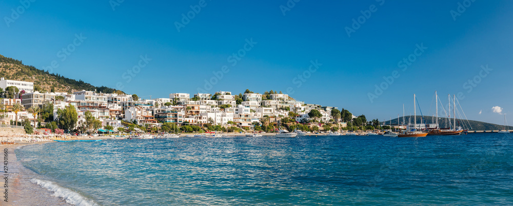 Fototapeta premium Panoramic View of Aegean sea, traditional white houses, marina, sailing boats and yachts in Bodrum city of Turkey. Aegean style turquoise water in Bodrum town Turkey.