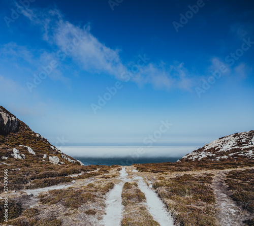 The path leading to sea between dry grassland in Wales. photo