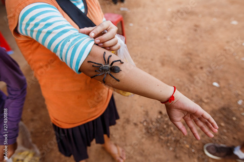 A child shows off a tarantula at a market near Siem Reap, Cambodia.