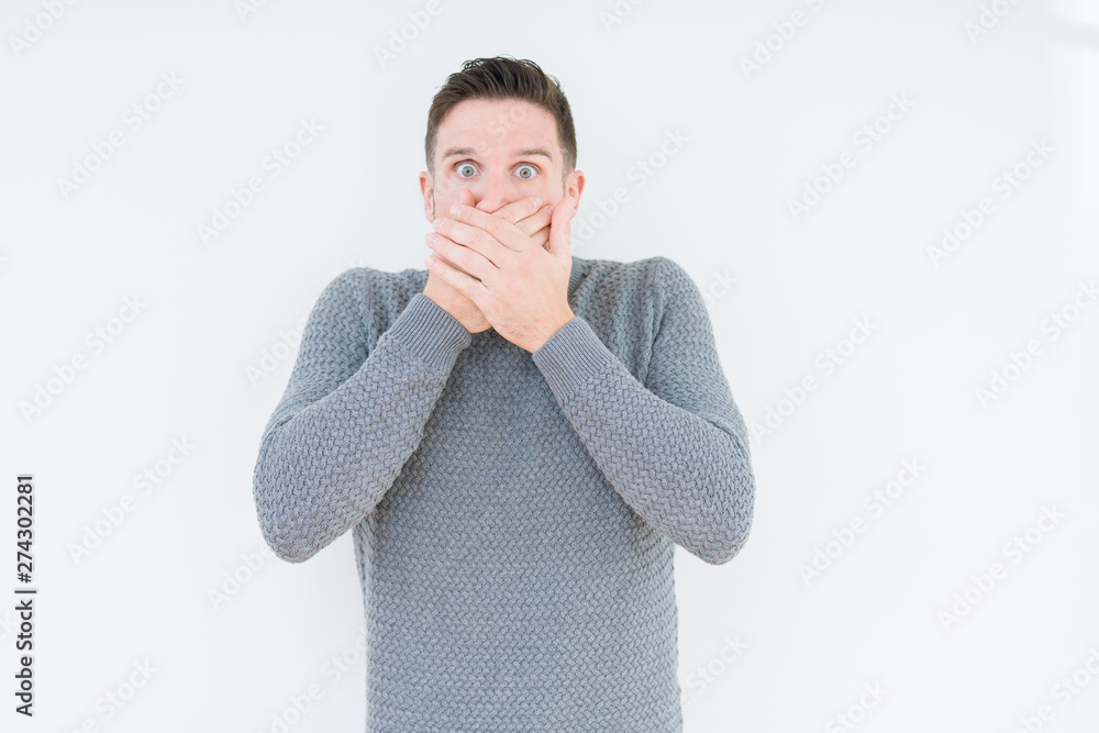 Young handsome man wearing casual sweater over isolated background shocked covering mouth with hands for mistake. Secret concept.