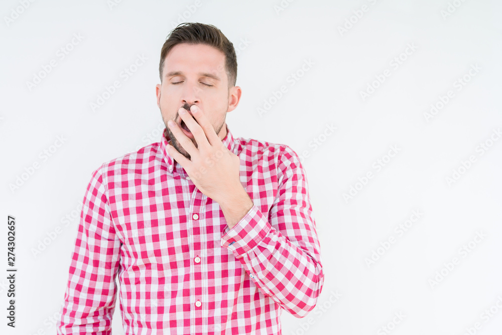 Young handsome man wearing shirt over isolated background bored yawning tired covering mouth with hand. Restless and sleepiness.