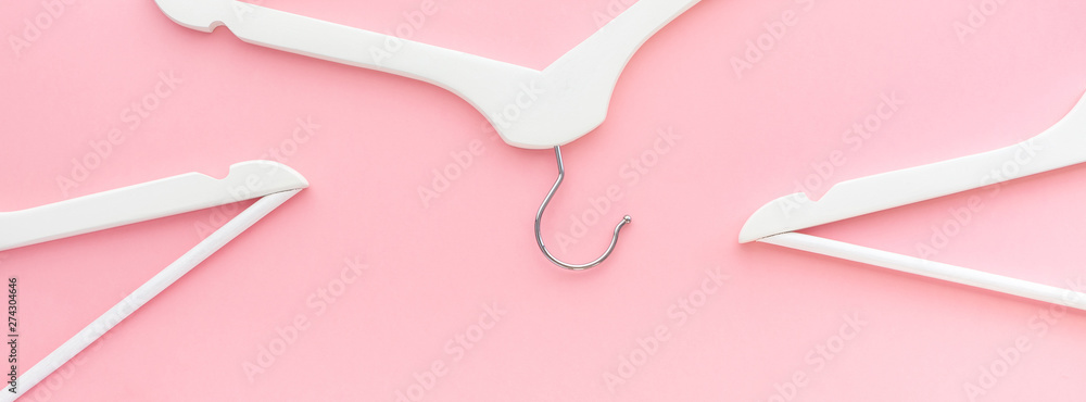 White hangers on pastel pink background White hangers on pastel pink background