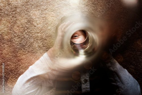 Boy looking through slinky photo