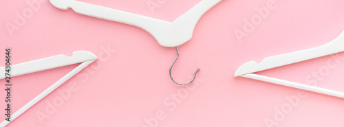 White hangers on pastel pink background