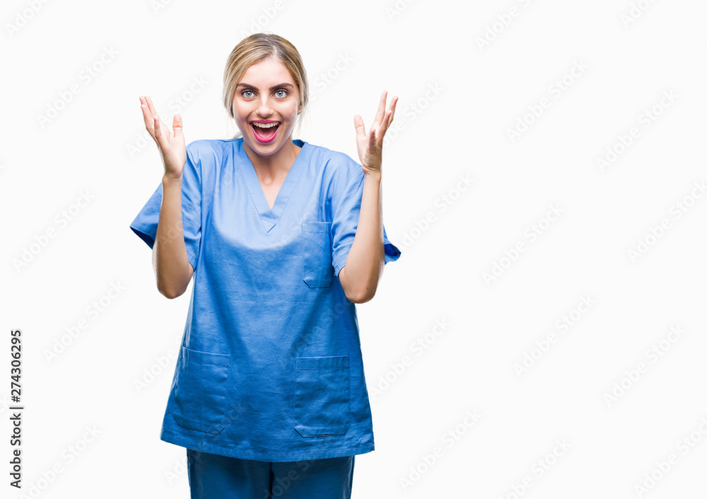 Young beautiful blonde doctor surgeon nurse woman over isolated background celebrating crazy and amazed for success with arms raised and open eyes screaming excited. Winner concept Young beautiful blonde doctor surgeon nurse woman over isolated background celebrating crazy and amazed for success with arms raised and open eyes screaming excited. Winner concept