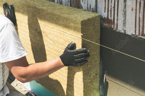 Konstfotografi Worker installing rock wool panels on facade wall