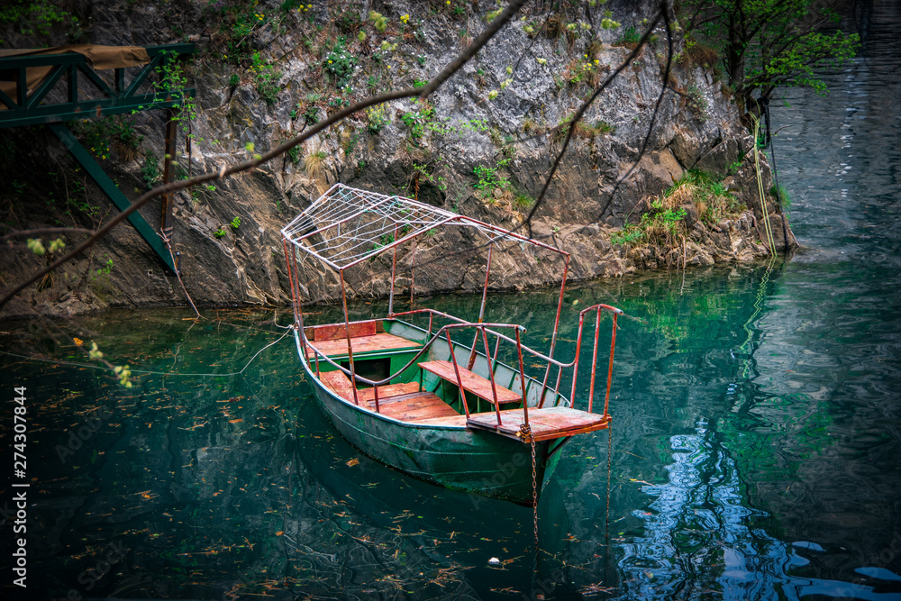 Landscape view of a green metal boat on colourful water. Canyon Matka, north Macedonia. Landscape view of a green metal boat on colourful water. Canyon Matka, north Macedonia.