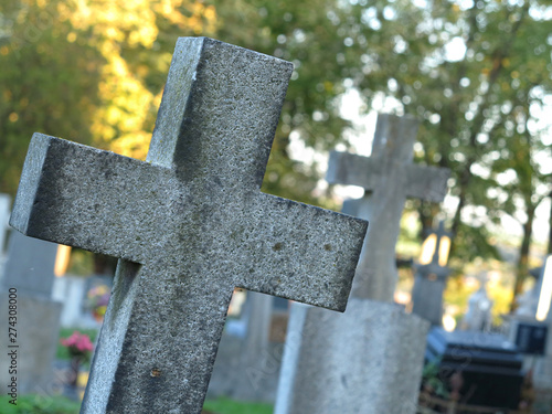 Several graves with granite crosses in cemetery, sunset