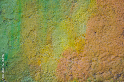 Abstract autumn background in yellow, green, and orange on a very rough and textured background.