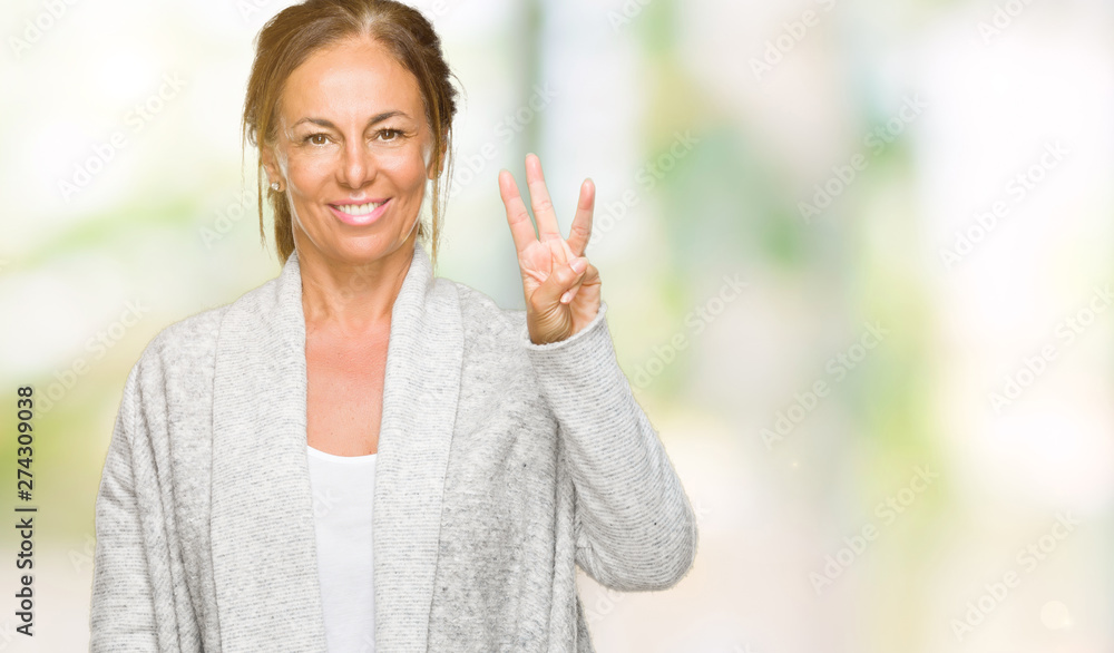 Beautiful middle age adult woman wearing winter sweater over isolated background showing and pointing up with fingers number three while smiling confident and happy. Beautiful middle age adult woman wearing winter sweater over isolated background showing and pointing up with fingers number three while smiling confident and happy.
