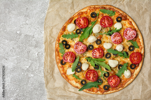 Vegetarian pizza with tomato, cheese, olives and arugula