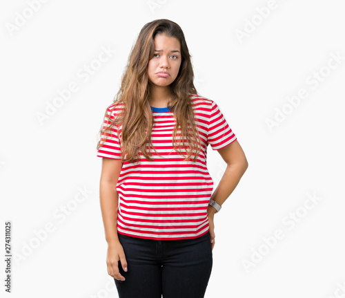 Young beautiful brunette woman wearing stripes t-shirt over isolated background depressed and worry for distress, crying angry and afraid. Sad expression. © Krakenimages.com