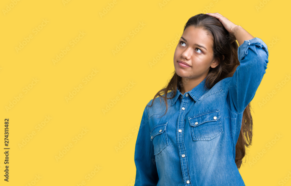 Fototapeta premium Young beautiful brunette woman wearing blue denim shirt over isolated background Smiling confident touching hair with hand up gesture, posing attractive