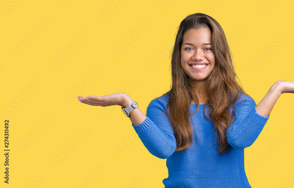 Young beautiful brunette woman wearing blue sweater over isolated background Smiling showing both hands open palms, presenting and advertising comparison and balance Young beautiful brunette woman wearing blue sweater over isolated background Smiling showing both hands open palms, presenting and advertising comparison and balance
